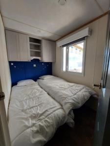 two beds in a small room with a window at Camping La Tentation in Renty +32 photos