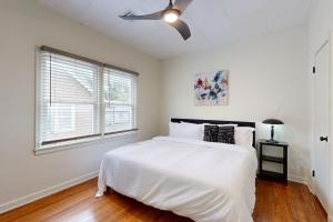 a white bedroom with a bed and a ceiling fan at Easy Access to OSU! 'Marvin's Manor' in Stillwater in Stillwater