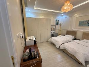 a bedroom with two beds and a table in it at غرفة نوم 3 أسرّة مدخل خاص بدون صالة in Al Baha