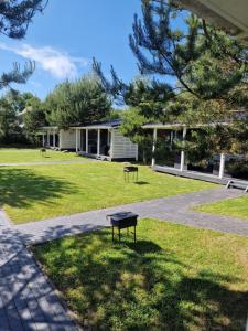 a bench in the grass in front of a house at Savas Uostas in Šventoji