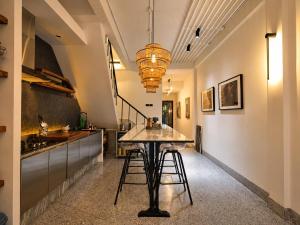 a kitchen with a table and stools in a room at Siri Designer 3-Storey Townhouse with Garden and Luxury Amenities in Bangkok