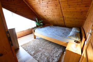 a bed in a wooden room with a window at Cabana Toth Mic&Mare in Sovata