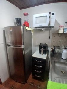 a small kitchen with a refrigerator and a sink at Pousadas JC 1 AP completo in Santarém +10 photos