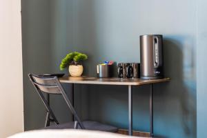 a table with a coffee maker and a plant on it at The Churchill Hotel in Coventry