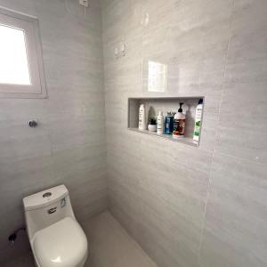 a bathroom with a toilet and a shelf on the wall at The Italian Studio7 in Dammam