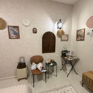 a room with two chairs and a table and clocks at The Italian Studio7 in Dammam