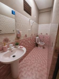 a pink bathroom with a sink and a toilet at Cleopatra Rest House in Nilaveli +31 photos
