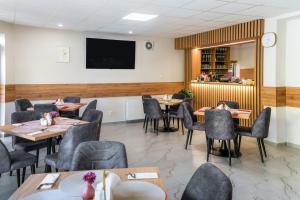 a dining room with tables and chairs and a tv at RS Hotel in Rimavská Sobota