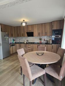 a kitchen with a table and chairs and a refrigerator at Guest House KATO in Poti