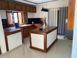 a kitchen with wooden cabinets and a island in it at Villa REEL in Morondava