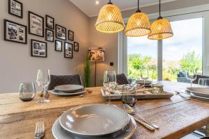 a dining room with a wooden table with plates and glasses at Püppi Hems Huus in Osterhever
