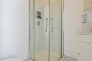 a shower with a glass door in a bathroom at The Churchill Hotel in Coventry +169 photos