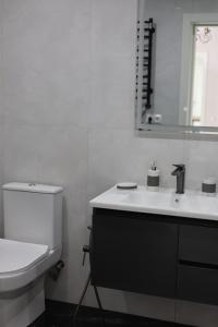 a white bathroom with a toilet and a sink at Sunny Home in Gandzakʼar