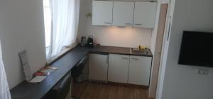 a kitchen with white cabinets and a sink and a window at Zimmer zum Viadukt in Neulengbach