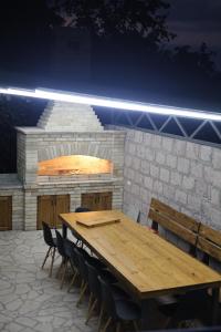 a wooden table and chairs in front of a brick oven at Sunny Home in Gandzakʼar