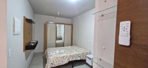 a small room with a bed and a mirror at Apartamento Universitário in Uberaba
