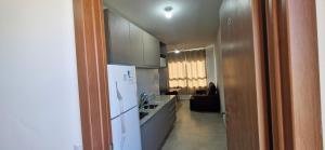 a kitchen with a white refrigerator and a counter top at Apartamento Universitário in Uberaba