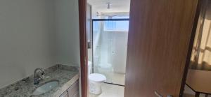a bathroom with a sink and a toilet and a shower at Apartamento Universitário in Uberaba +4 photos