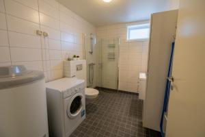 a bathroom with a washing machine and a toilet at Havnegata Apartments in Vadsø