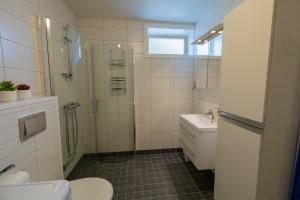 a bathroom with a shower and a toilet and a sink at Havnegata Apartments in Vadsø