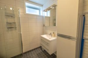 a white bathroom with a sink and a mirror at Havnegata Apartments in Vadsø