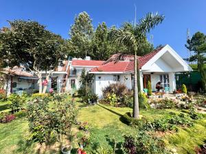 a white house with a palm tree in the yard at Candy Ville Resorts in Coonoor