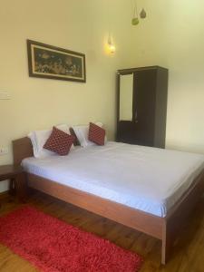 a bedroom with a large bed with a red rug at Candy Ville Resorts in Coonoor