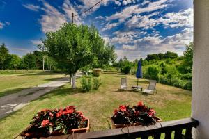 a balcony with two chairs and flowers and an umbrella at Guesthouse Spektar in Irinovac