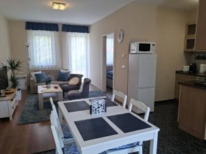 a kitchen and a living room with a table and chairs at Blue Iris Apartment in Kecskemét