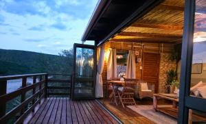 a cabin with a table and chairs on a deck at Gourits River Guest Farm in Mossel Bay