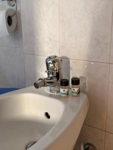 a bathroom sink with two jars on top of it at Aperto Tuscany apartment in Torrenieri