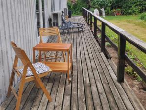 two chairs and a table on a wooden deck at Valiant B&B in Otterbäcken +8 photos