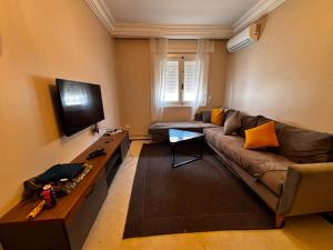 a living room with a couch and a flat screen tv at Appartement Bizerte Nord in Bizerte