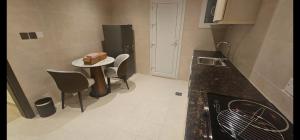 a kitchen with a table with chairs and a cake on it at Salalah Royals Residence in Daḩārīz