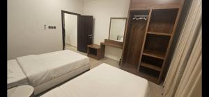 a small bedroom with a bed and a mirror at Salalah Royals Residence in Daḩārīz +2 photos