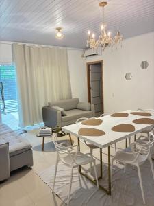 a living room with a table and a couch at Jardim Florestal Italy-Casa Jacarandá in Itaquatiara +15 photos