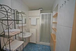 a white bathroom with a sink and a shower at Appartements Berger Kitzbühel in Kitzbühel +134 photos