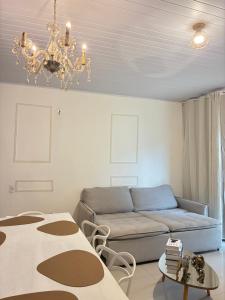 a living room with a couch and a chandelier at Jardim Florestal Italy-Casa Jacarandá in Itaquatiara