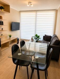 a living room with a glass table and black chairs at Ale Canal Beagle in Viña del Mar