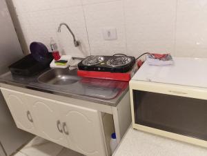 a small kitchen with a stove and a sink at Casinha da Alê in Mongaguá