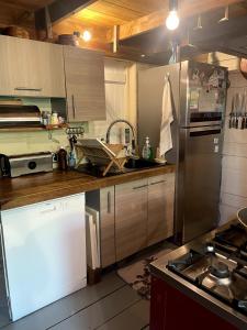 a kitchen with a stainless steel refrigerator and a sink at L'Escale Cosy in Saint-Paul