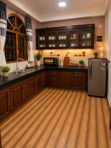 a kitchen with wooden cabinets and a refrigerator at Cleopatra Rest House in Nilaveli