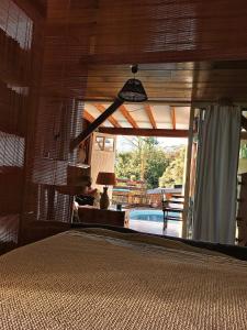 a bedroom with a view of a swimming pool and a room with a bed at L'Escale Cosy in Saint-Paul