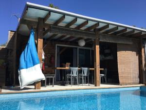 a pavilion with a pool and a table and chairs at L'Escale Cosy in Saint-Paul