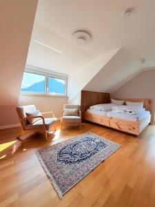 a bedroom with a bed and a chair and a rug at Alpenzeit - Ferienhaus mit Sauna, Garten und Bergblick bei Garmisch-Partenkirchen in Farchant