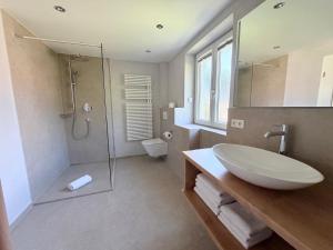 a bathroom with a sink and a shower and a toilet at Alpenzeit - Ferienhaus mit Sauna, Garten und Bergblick bei Garmisch-Partenkirchen in Farchant +14 photos