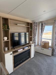 a living room with a flat screen tv and a entertainment center at Teal - a few steps from the beach in Redcar