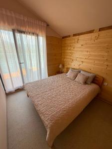 a bedroom with a large bed and a window at Splav Astra Perućac in Perućac