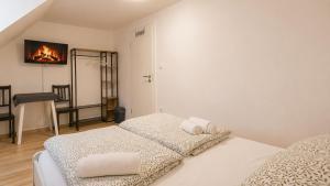 two beds in a room with a fireplace on the wall at 92 City Rooms in Koblenz