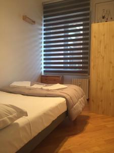 ボローニャにあるAppartamento Medaglie D'oroのベッドルーム1室(ベッド2台、ブラインド付きの窓付)が備わります。